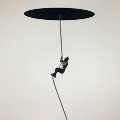 a man hanging from a rope while riding a surfboard