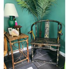 a chair sitting next to a table with a lamp on top of it and a potted plant in the corner