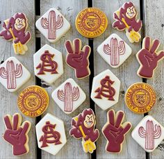 many decorated cookies are arranged on a wooden table with cactus, and other items in the background