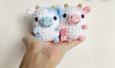 two small crocheted animals sitting on top of each other in the palm of a person's hand