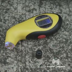 a digital thermometer sitting on top of a stone floor next to a screwdriver