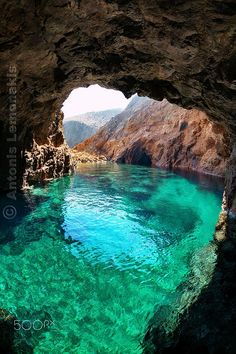 the water is crystal clear and blue in this cave entrance, which looks like it could be underwater