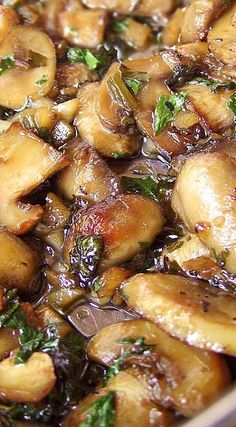 mushrooms and greens cooking in a pan on the stove