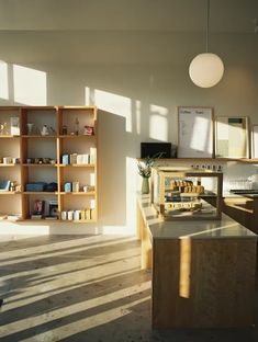 the sun shines through windows in an empty room with bookshelves and shelves