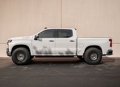 a white pickup truck parked in front of a building with no doors on it's sides