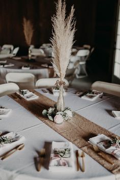 the table is set with white linens and pamylum centerpieces for an elegant wedding reception