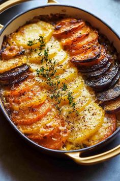 a casserole dish with potatoes, onions and parmesan cheese