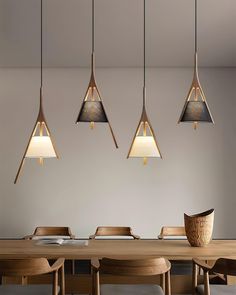 a dining room table with four hanging lights above it