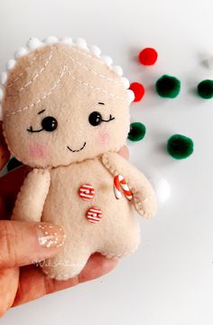 a hand holding a small stuffed animal with candy canes