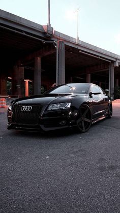 a black car parked in front of a parking garage