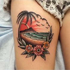 a woman's thigh with a sunset and flowers on it