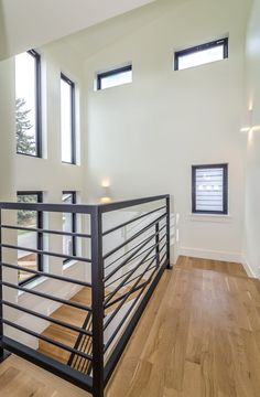 an empty room with wood flooring and metal handrails in the middle of it