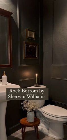 a white toilet sitting next to a sink in a bathroom under a mirror with the words rock bottom by sherylin williams