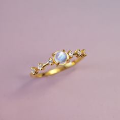 Introducing Moonlight – a delicate and enchanting ring crafted from 14k solid gold, featuring a mesmerizing moonstone as its centerpiece, with sparkling white topaz accents. The moonstone’s ethereal glow shimmers with soft hues of blue and white, reminiscent of moonbeams dancing across a calm night sky. The brilliant white topaz stones are tiny stars, adding just the right touch of elegance and radiance. Perfect for both everyday wear and special occasions, Moonlight embodies a timeless blend of Calm Night, White Topaz Rings, Tiny Star, Ring Crafts, Topaz Stone, Moon Child, Topaz Ring, White Topaz, Night Sky