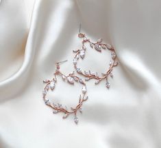 Complete your bridal look with the elegance of our APRILLE earrings. These large, rose gold statement earrings feature a stunning vine design adorned with sparkling cubic zirconia, offering a touch of refined luxury. Not only are they lightweight and comfortable, but they also add a sophisticated and exclusive flair to any wedding ensemble." - Handcrafted in my PA Studio- Earrings measure 3" x 2"- Premium Cubic Zirconia stones- Available in rose gold, yellow gold and rhodium finish.- Nickel free and hypoallergenic- PLEASE ALLOW APPROX 3-5 BUSINESS DAYS FOR COMPLETION BEFORE SHIPPING.This is an original design by © Treasures by Agnes TO SEE OUR ENTIRE APRILLE COLLECTION PLEASE TYPE "APRILLE" IN THE SEARCH BAR Statement Wedding Earrings, Rose Gold Statement Earrings, Bridal Backdrop Necklace, Gold Bridal Hair Comb, Statement Earrings Wedding, Bridal Statement Earrings, Backdrops Necklace, Crystal Bridal Earrings, Cubic Zirconia Bracelet