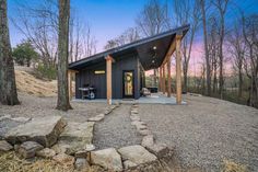 a small cabin in the woods with stone steps leading up to it's entrance