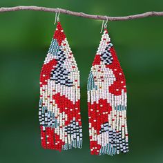 two pairs of beaded earrings hanging from a branch