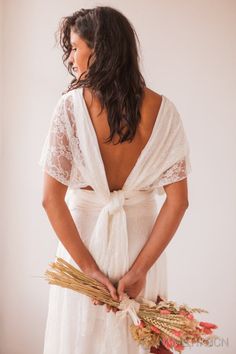 a woman in a white dress holding flowers