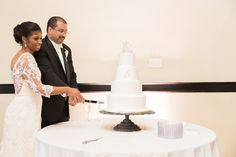 a bride and groom cutting their wedding cake