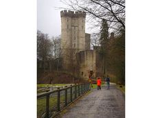 two people walking down a path towards a castle