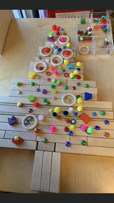 a christmas tree made out of wooden pegs and colored beads on a table top