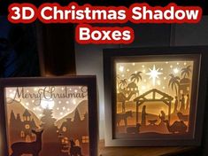 two christmas shadow boxes are sitting on a table