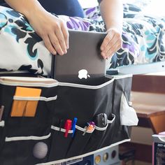 a woman is holding a laptop in her bag