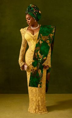 a woman in a yellow dress and green shawl is standing with her hands on her hips