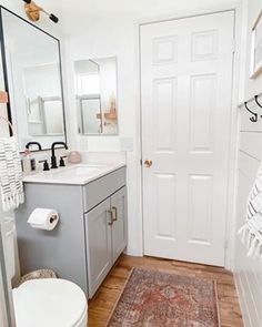 a bathroom with a toilet, sink and mirror in it's corner next to a door