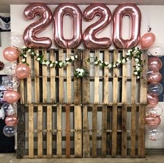 a wooden pallet with balloons and flowers on the top that read 2050s