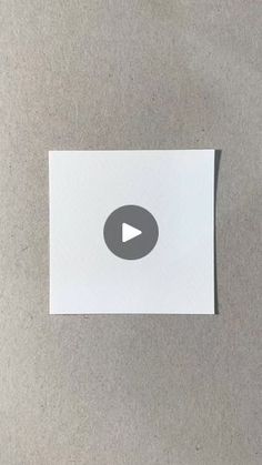 a white piece of paper with a video play button on the bottom right corner and an arrow in the middle left corner