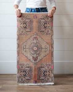 a woman holding an old rug in front of her face