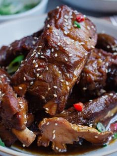 some meat with sesame seeds and sauce on a plate