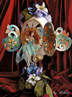 a doll is sitting on top of a flower vase with flowers and butterflies around it