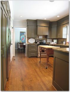 a kitchen with wooden floors and gray cabinets