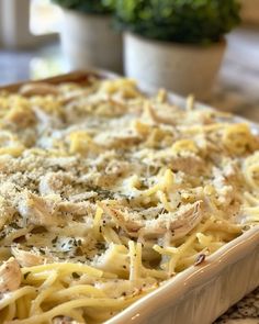 a casserole dish with chicken, cheese and parmesan on the side