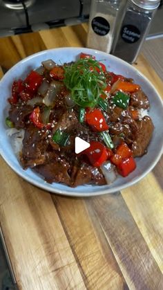 a white plate topped with meat and veggies on top of a wooden table