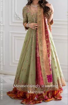 a woman in a green and pink lehenga