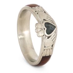 a ring with a skull on it and a green stone in the middle, sitting on top of a white surface