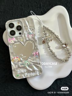 a cell phone case sitting on top of a white plate next to a silver ball chain