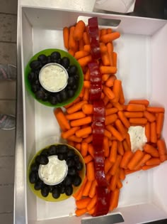 carrots and black olives are arranged in the shape of an x with dip