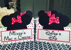 two mickey mouse ears with red bows on their heads and name tags attached to them