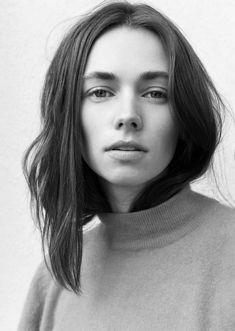 a black and white photo of a woman with long hair wearing a turtle neck sweater