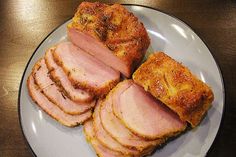 slices of ham on a plate sitting on a table