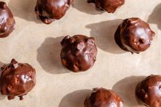 chocolate covered doughnuts sitting on top of a baking sheet