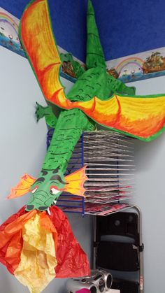 there is a paper dragon on the wall above some scissors and other items in front of it