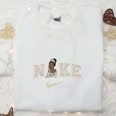 Tiana x Nike Embroidered Shirt, Disney Princess Embroidered Hoodie, Best Gifts For Family Tinicloset is a whimsical haven nestled amidst the bustling fashion landscape, where every stitch tells a story and every thread weaves magic into everyday wear. As you step into our cozy enclave, the air is laden with a medley of cotton and creativity, welcoming you into a realm where custom embroidery adorns the canvas of shirts, sweatshirts, T-shirts, and hoodies, turning the ordinary into the extraordin Cute Disney Shirts, Winnie The Pooh Shirt, Best Family Gifts, Maroon Hoodie, Fashion Landscape, Nike Shirt, Hoodie Material, Embroidered Sweater, Blue Sweatshirt