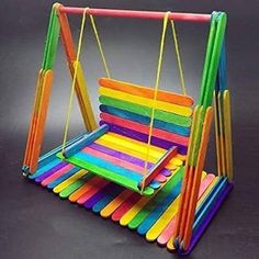 a toy swing made out of colored sticks