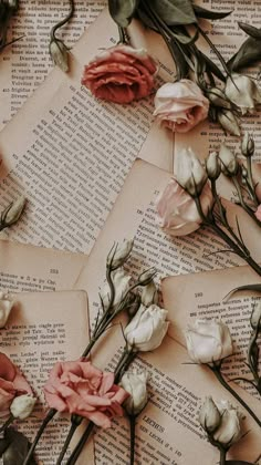 some flowers are laying on top of an old book with pages that have been torn down