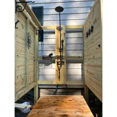 an outdoor shower in the back yard with wooden boards on the sides and doors open